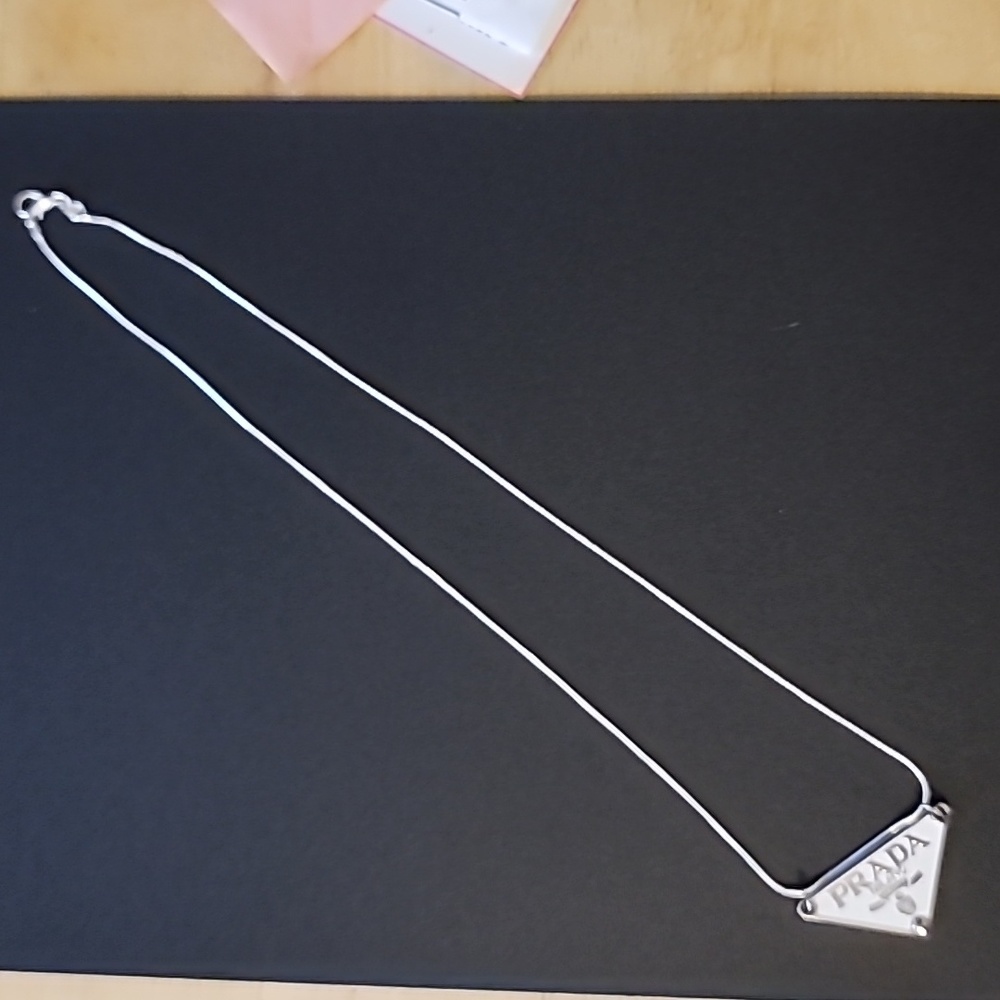 Prada logo with silver chain.